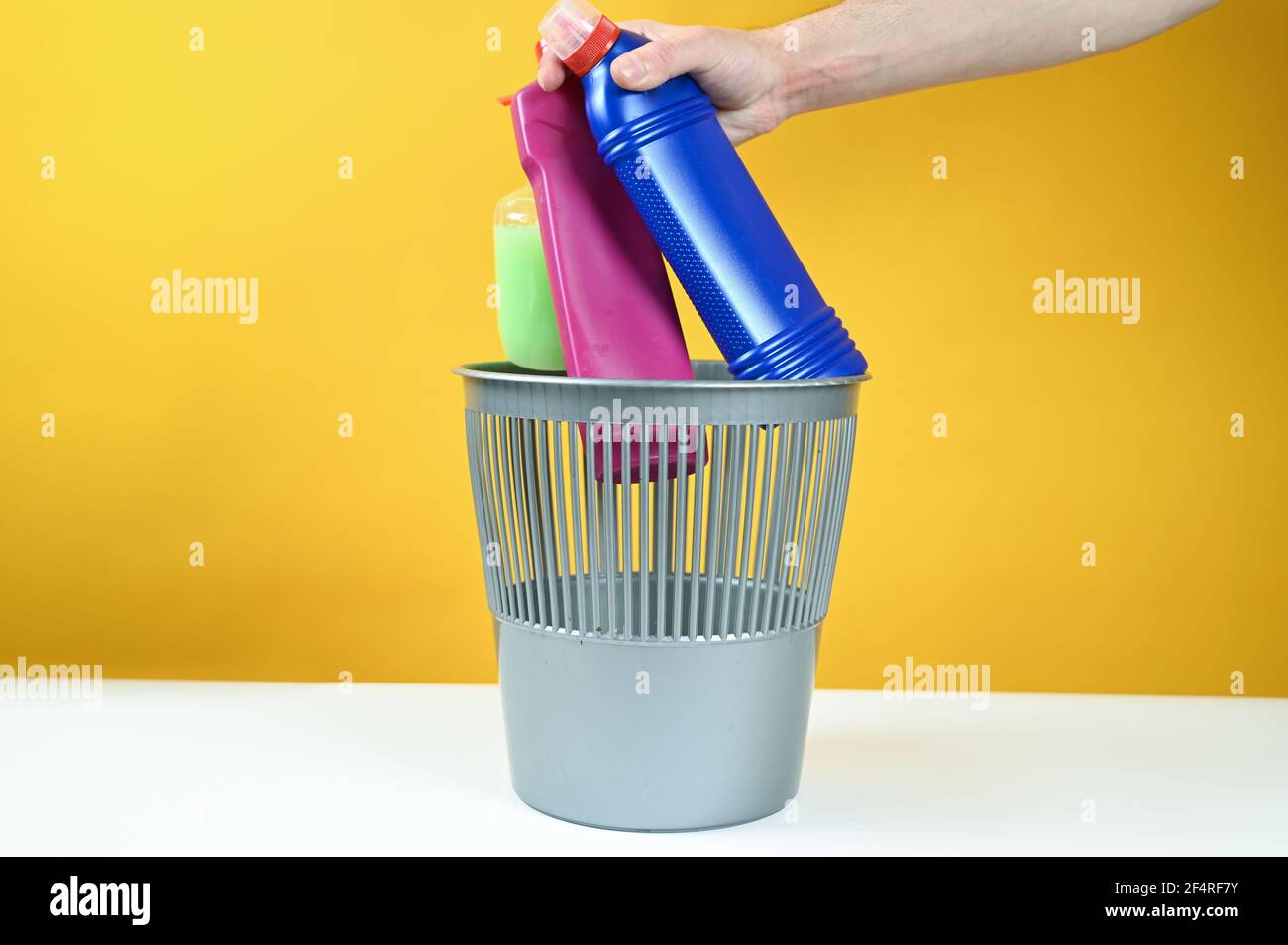 Man hand throwing a empty plastic water bottles into the trash can ...