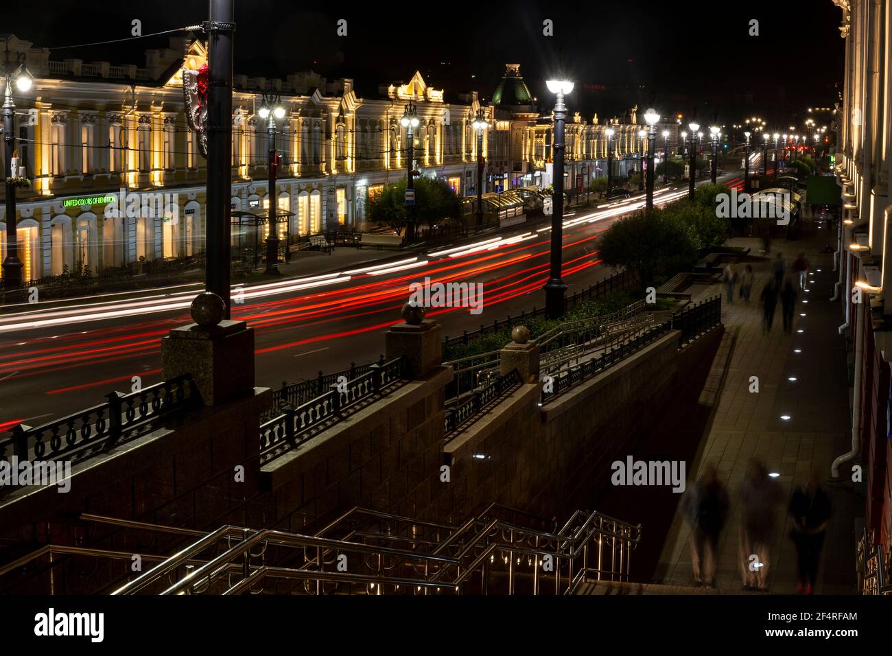 Omsk, Russia - September 13, 2019: People in the streets of Omsk with great architectural buildings at night with red car lights, Siberia, Russia. Stock Photo