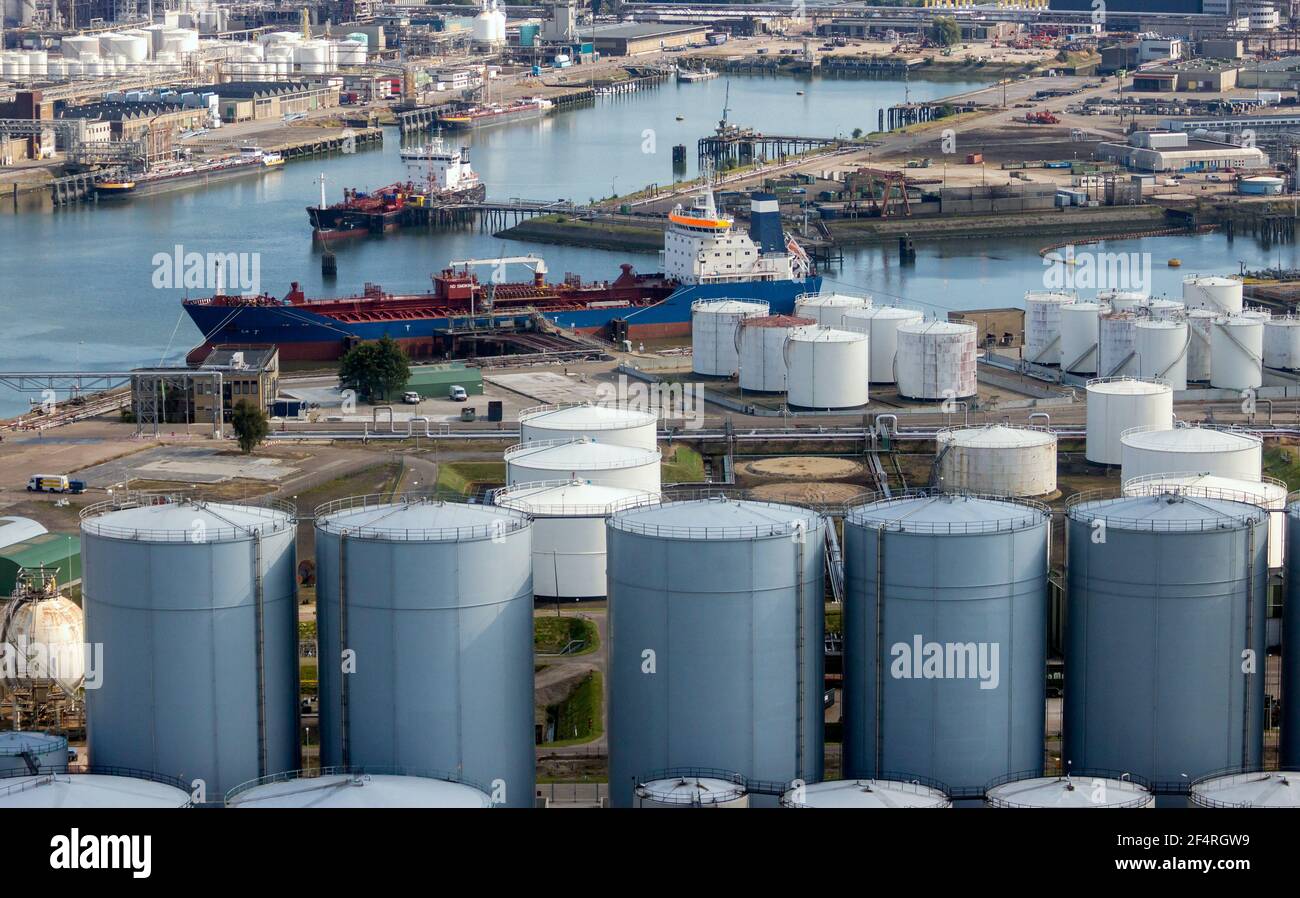 Aerial view of an oil tanker moored at an oil storage silo terminal port. Stock Photo