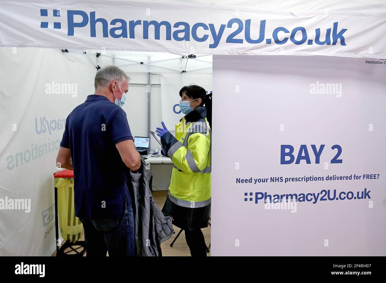 EDITORIAL USE ONLY Former Wallis and Evans multi-site manager, Jackie Bond  assists members of the public at at Pharmacy2U's new Covid-19 vaccination  site, at a former Topshop store in Workington, which has