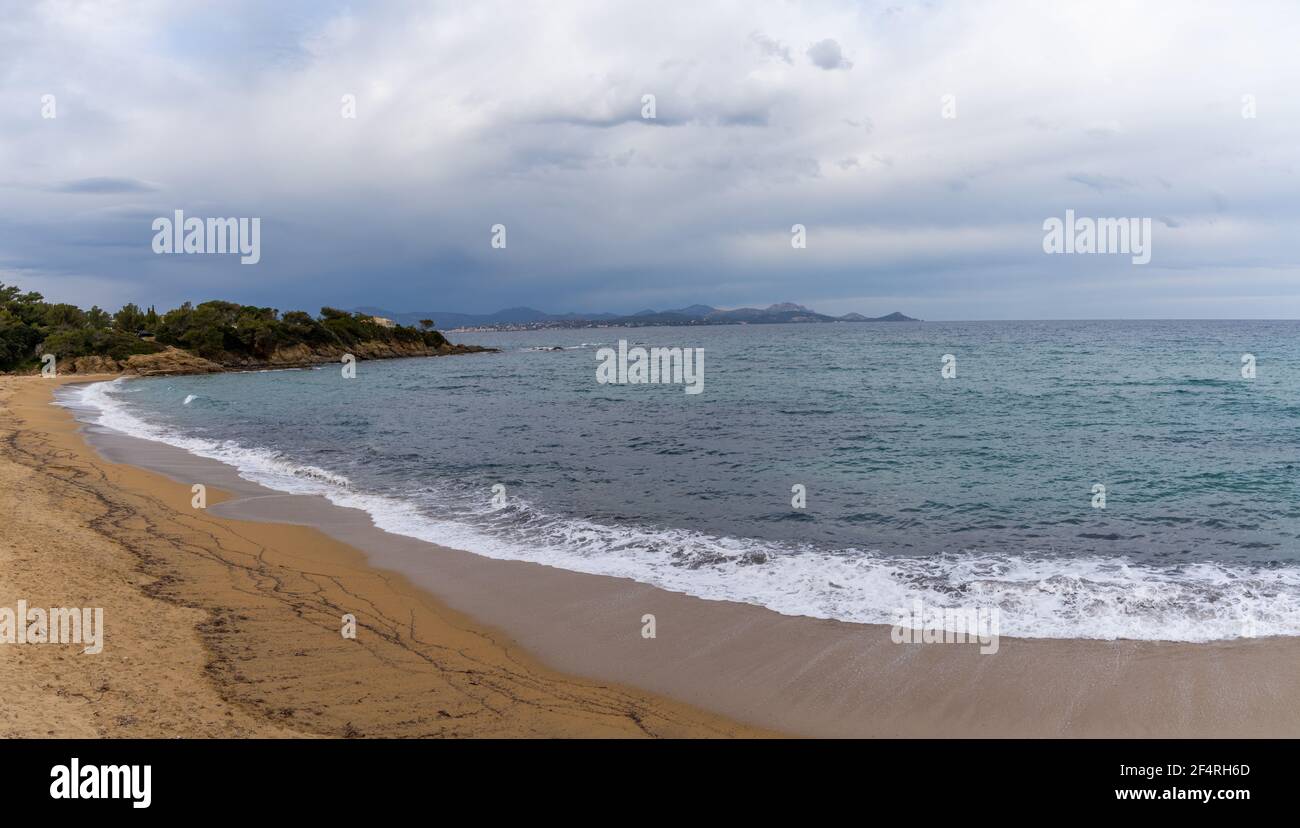 Empty peaceful golden sand beach on the French Riviera under an expressive overcast sky Stock Photo