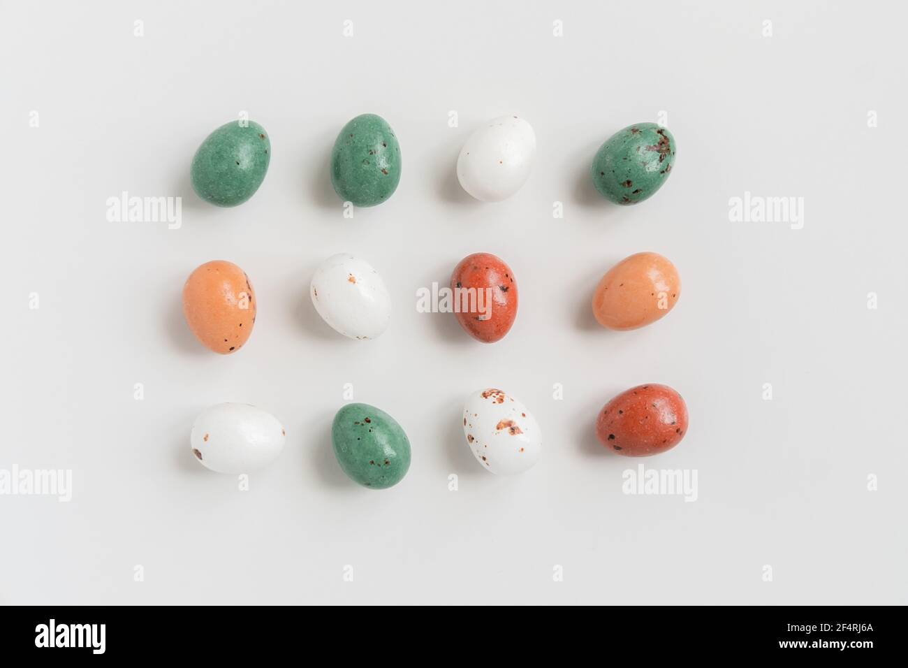 Easter minimal composition with multicolored eggs on the white background. Easter concept. Copy space, flat lay. Stock Photo