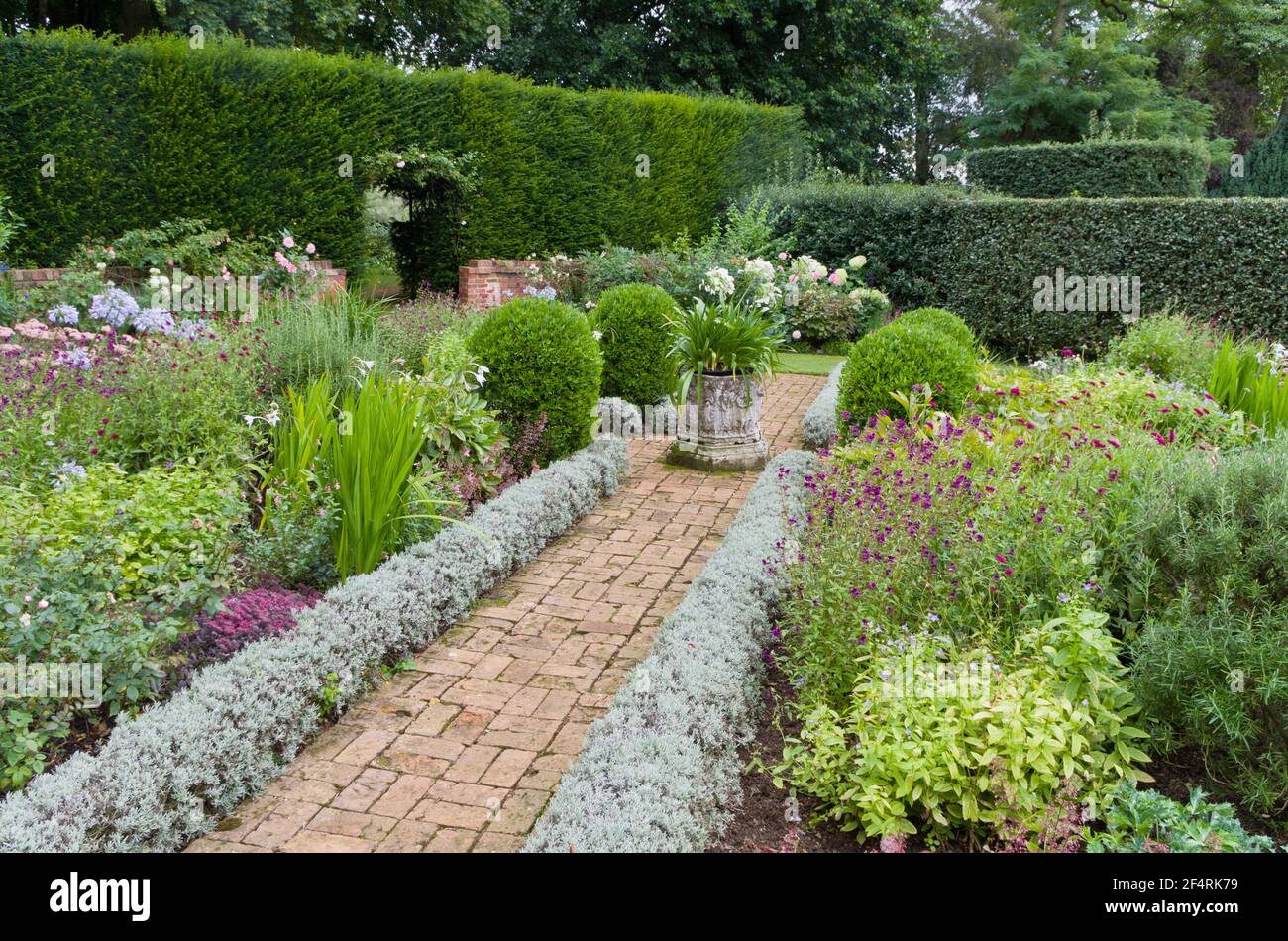 Paved path with herbaceous borders in summer, Coton Manor Gardens, Northamptonshire, UK Stock Photo