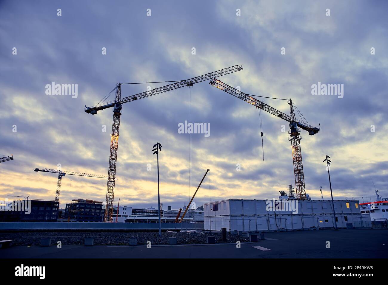 Construction cranes against the dark sky background Stock Photo - Alamy