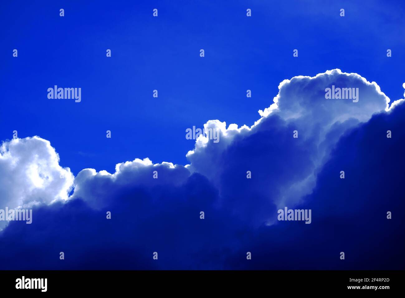 Silver lined cumulus cloud against deep blue sky Stock Photo