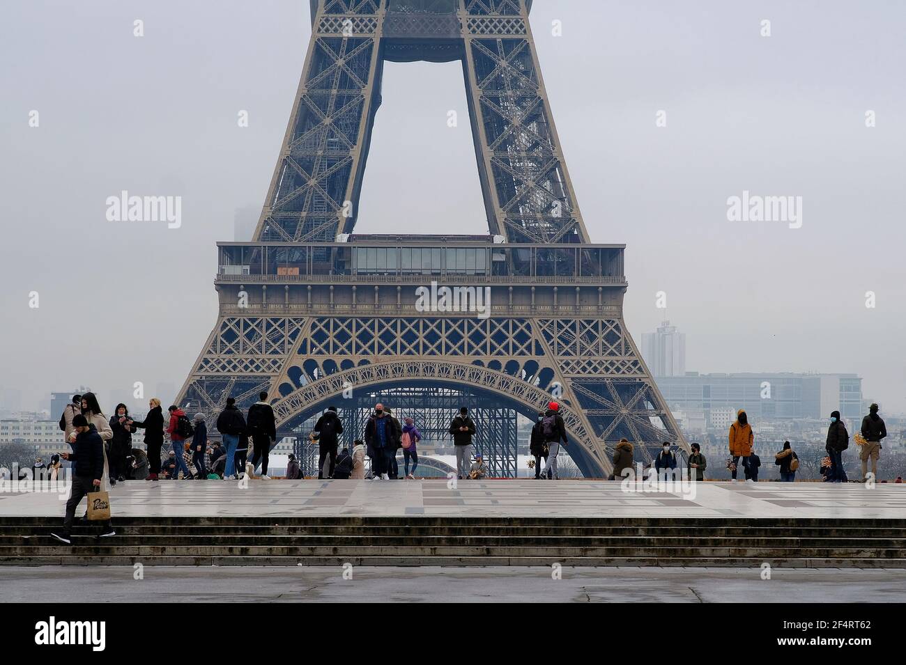 Paris, France - Janauary 31, 2021 : Tourists and parisians in front of the Eiffel Tower in Paris during covid restrictions. Stock Photo