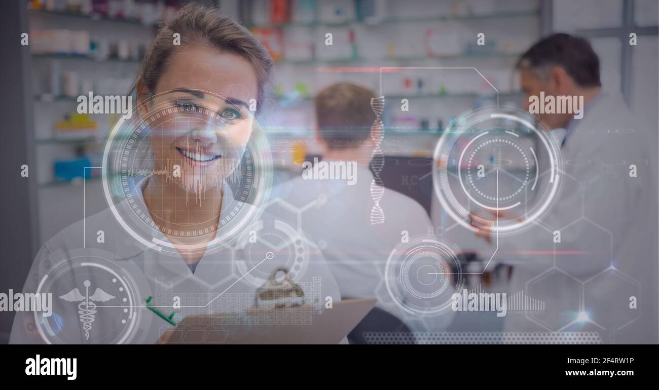 Digital interface with medical data processing against female health worker holding clipboard Stock Photo