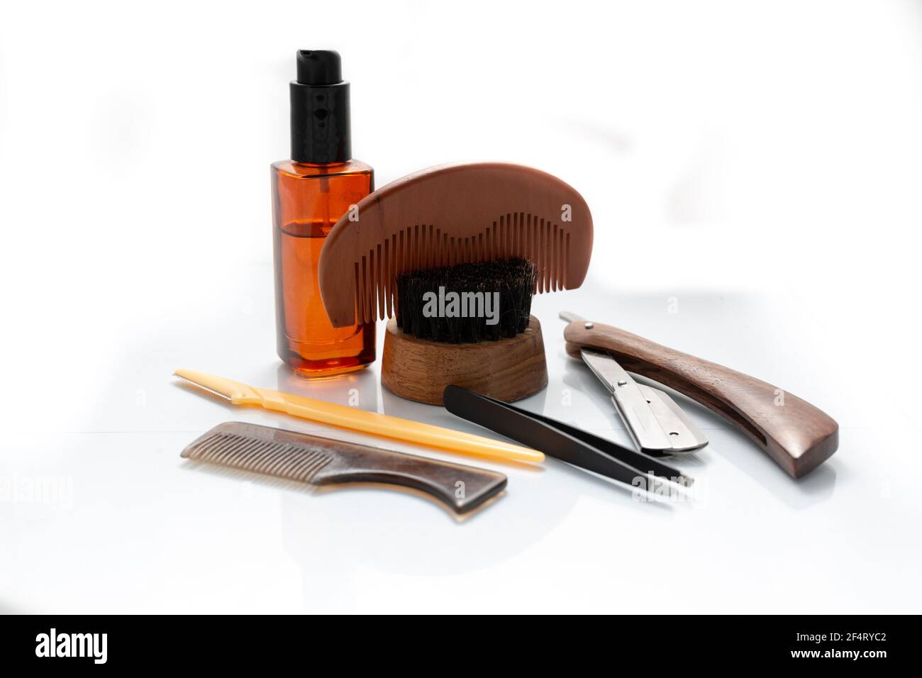 A selection of men's beard grooming products that include oil, cut throat razor and a brush, shot against a clean white background Stock Photo
