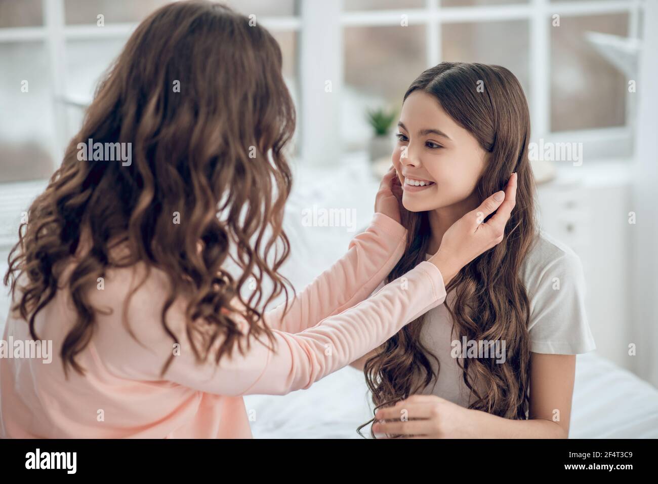 Woman touching the head of smiling girl Stock Photo - Alamy
