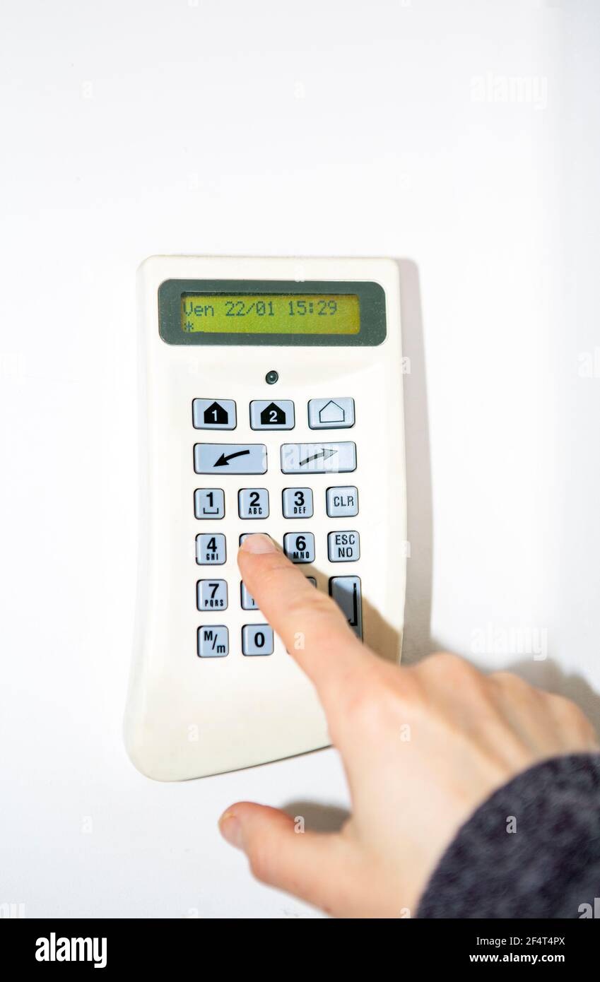 Alarm system, woman's hand entering the code in security panel to unlock the alarm Stock Photo