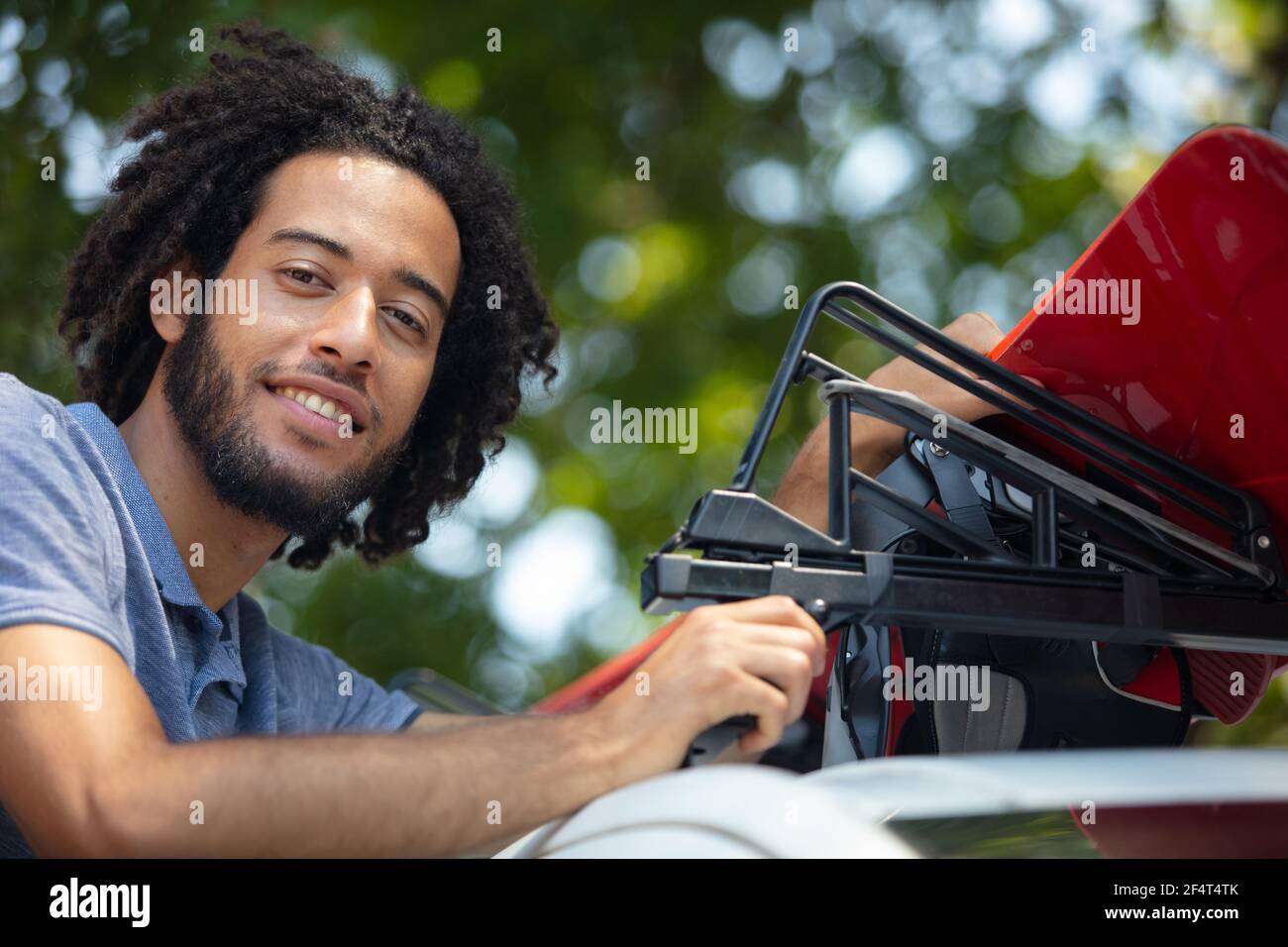 man installing a car roof rack outdoors Stock Photo Alamy