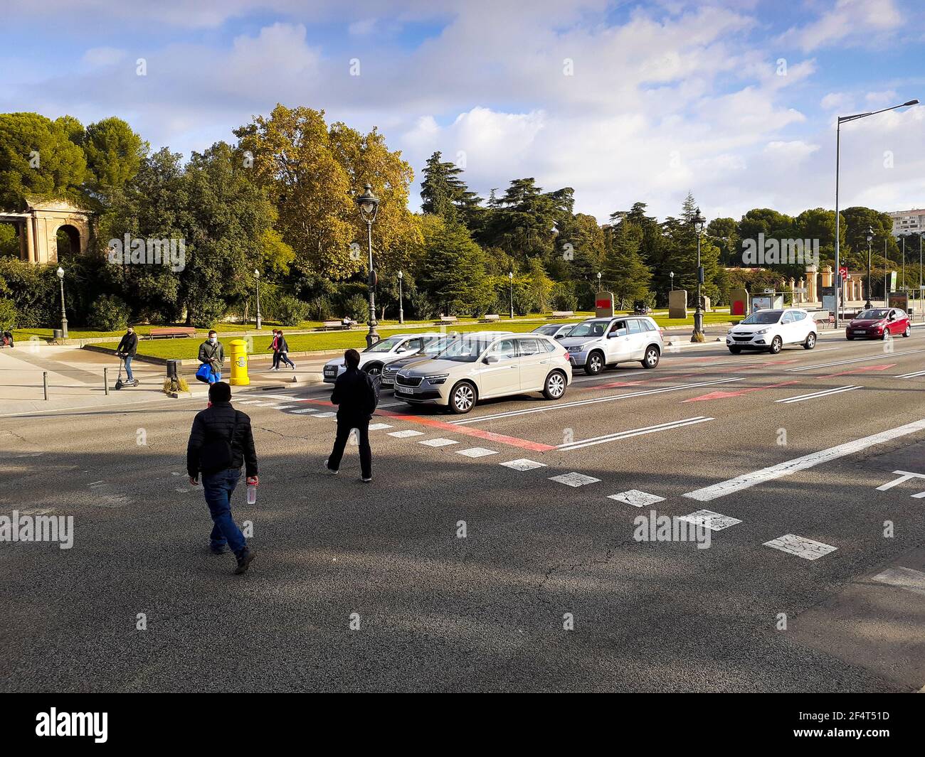 People crossing street while cars are stopped in a traffic light Stock ...