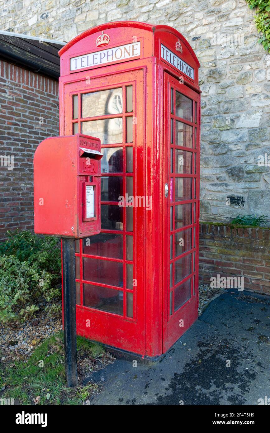 A traditional red Royal Mail postbox alongside red telephone kiosk in the village of Towton, North Yorkshire Stock Photo