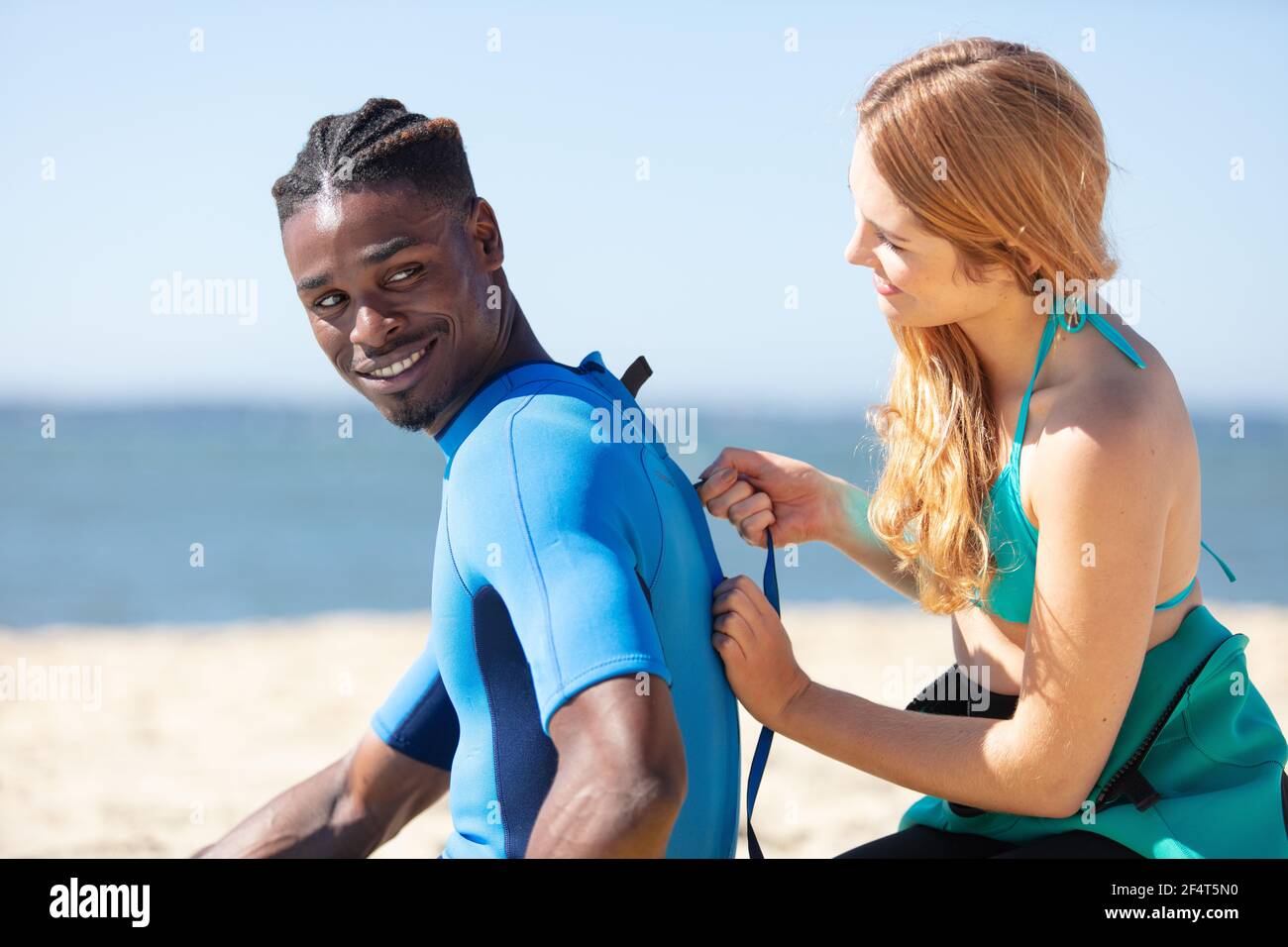 couple wearing wetsuits on surfing staycation Stock Photo Alamy