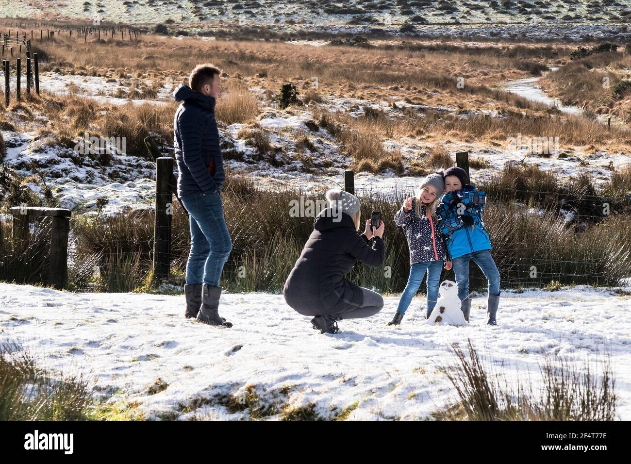 A faily having fun in the Snow on the wild rugged Bodmin Moor in Cornwall. Stock Photo