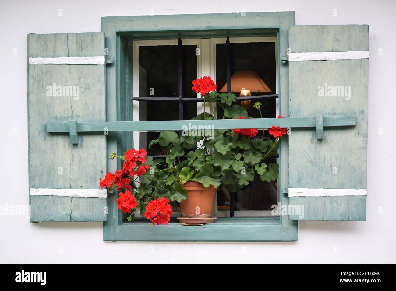 window of alpine house with geranium flowers Stock Photo - Alamy