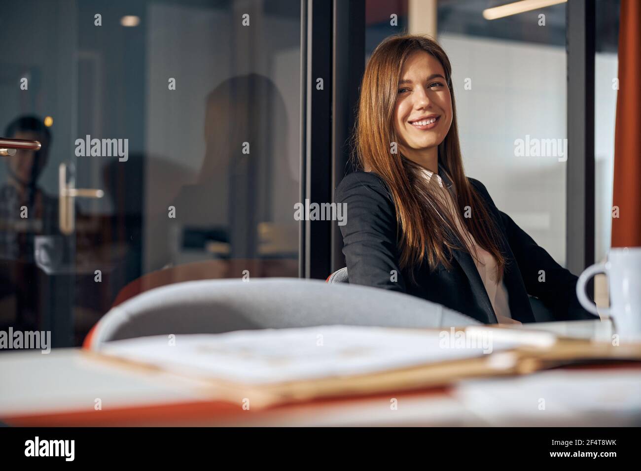 High-spirited stylish businesswoman smiling at the camera Stock Photo