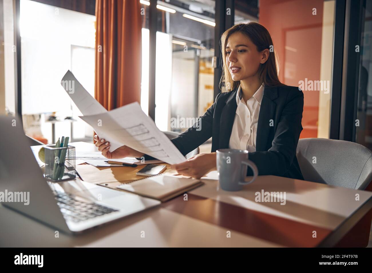 Concentrated female designer analyzing the building plans Stock Photo