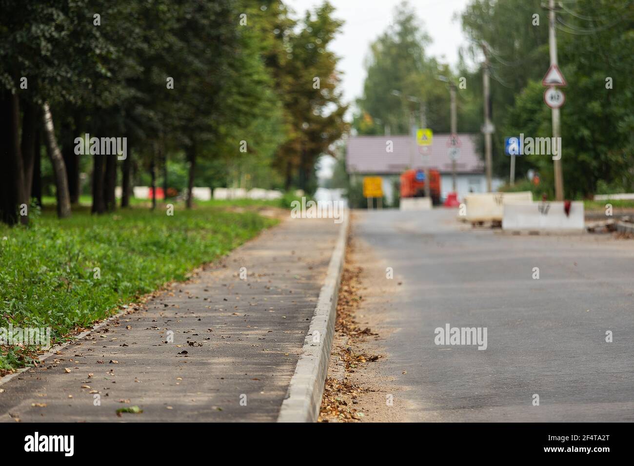poorly executed road repairs. replacing the old curb stone with a new one Stock Photo