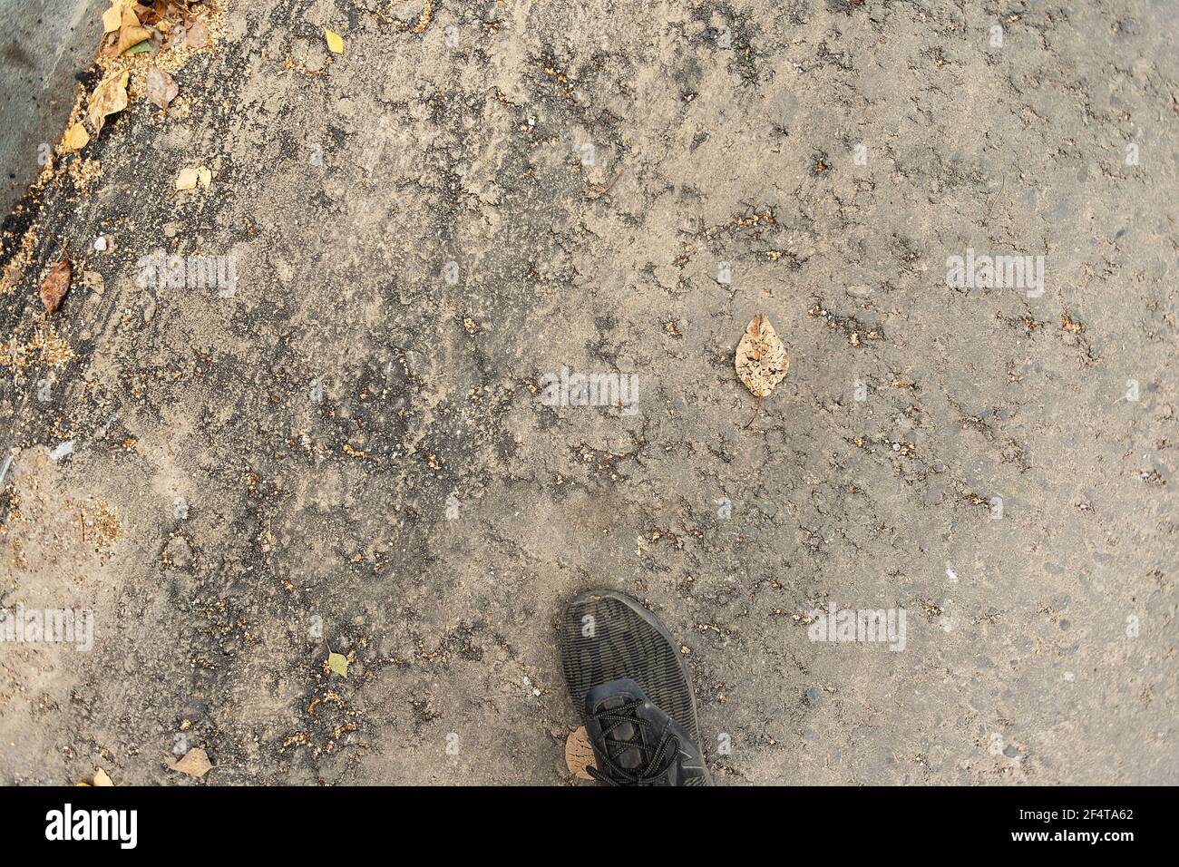 poorly executed road repairs. replacing the old curb stone with a new one Stock Photo