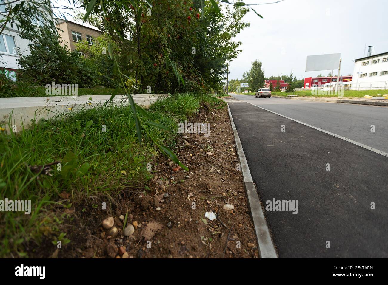 poorly executed road repairs. replacing the old curb stone with a new one Stock Photo