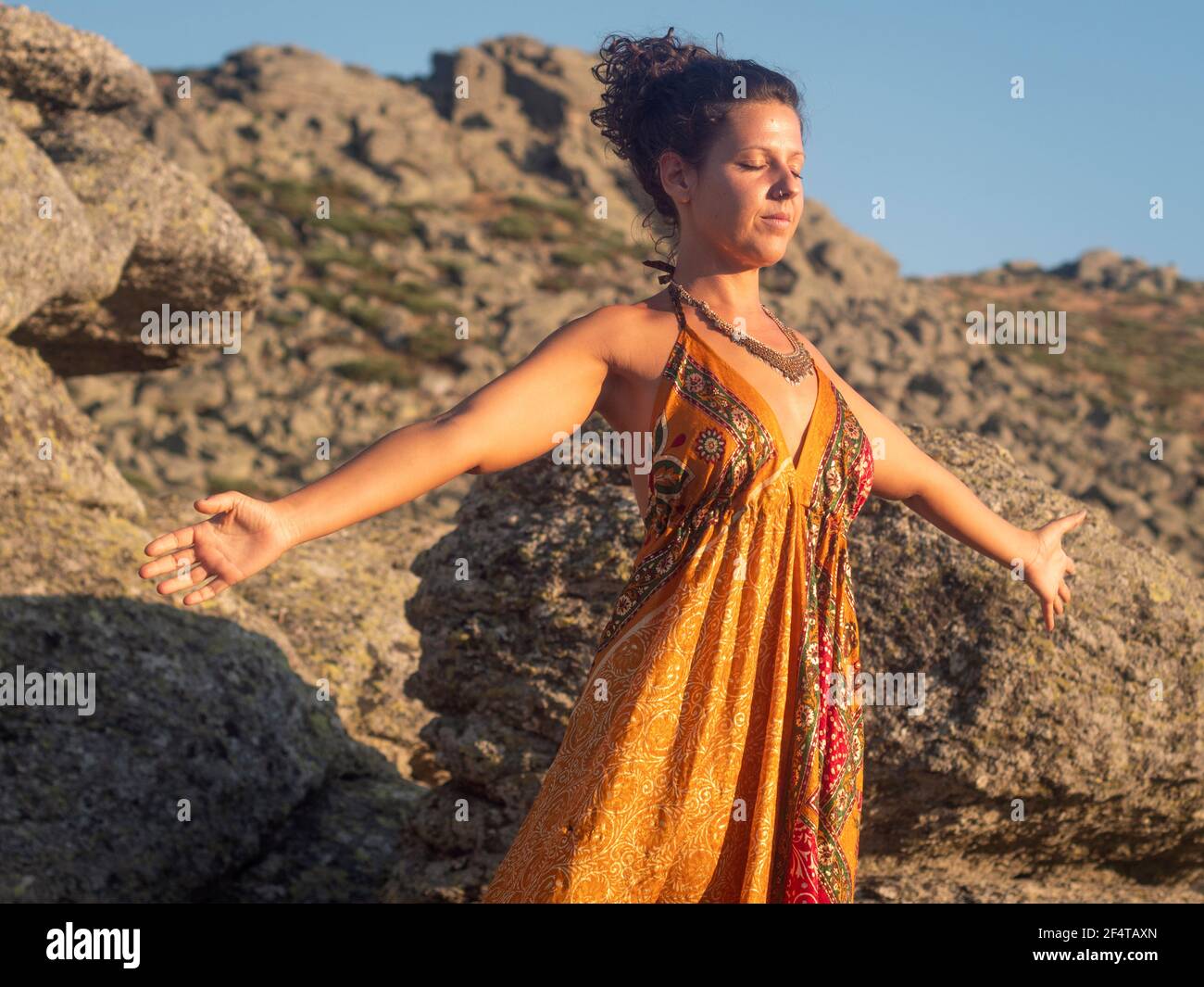 Horizontal view of caucassian female practicing breathing techniques in the sunset. Stock Photo