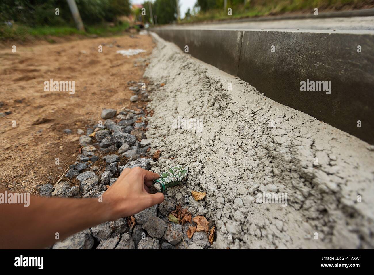 poorly executed road repairs. replacing the old curb stone with a new one Stock Photo