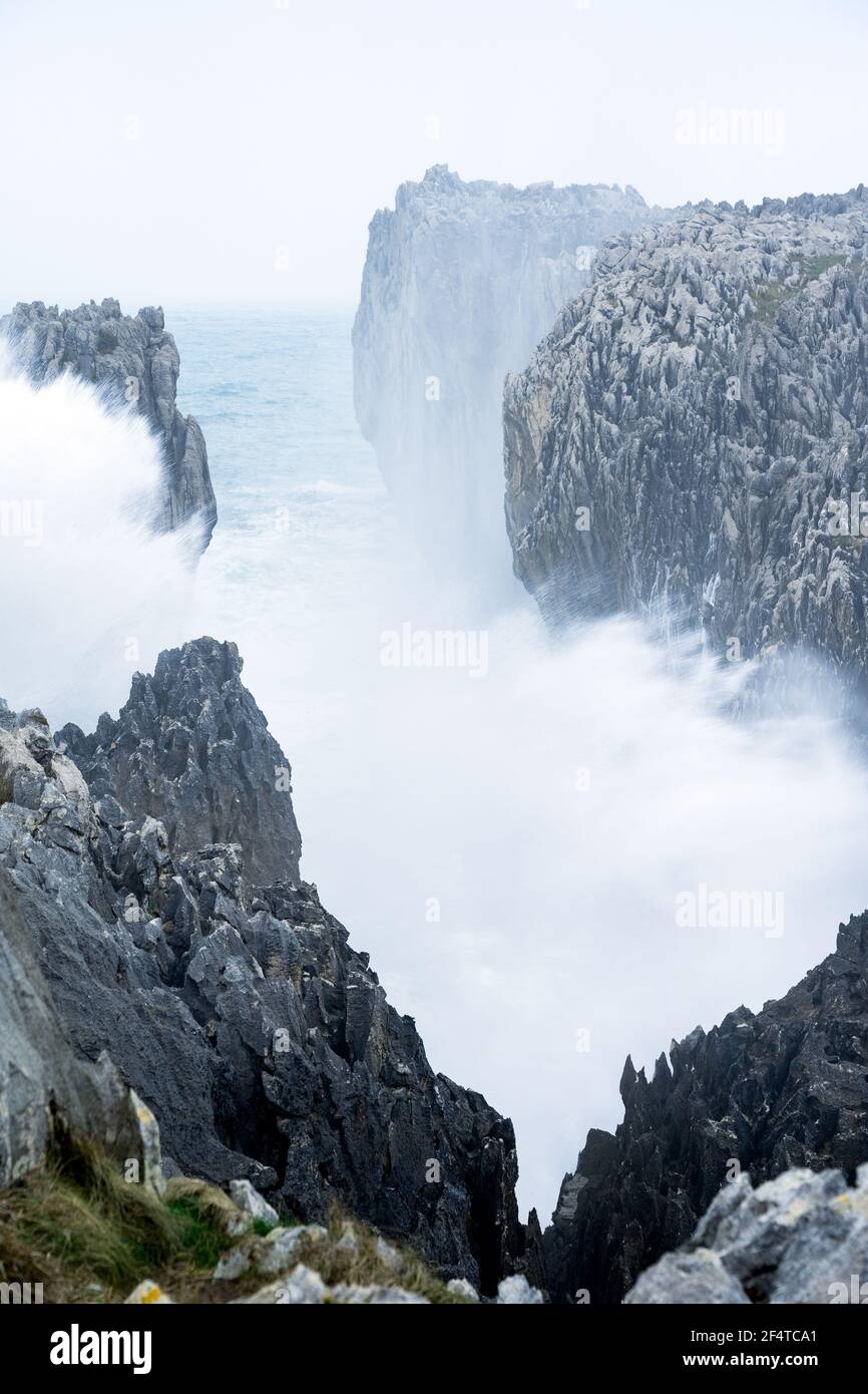 Waves crashing against the karst limestone sea cliffs in Asturias ...