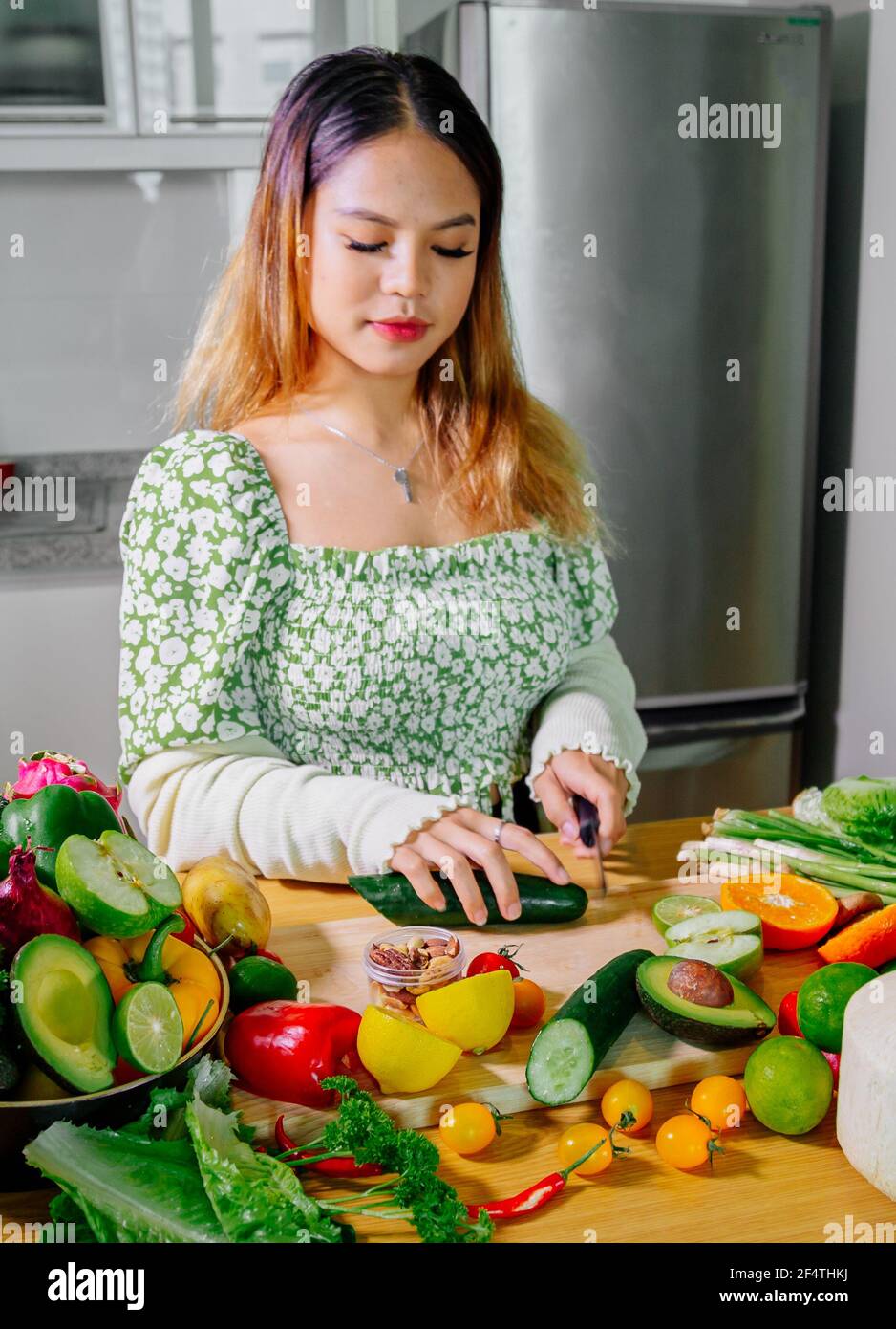 Asian girl cooking healthy vegetarian and vegan food, vegetables and fruits in the kitchen, healthy lifestyle Stock Photo