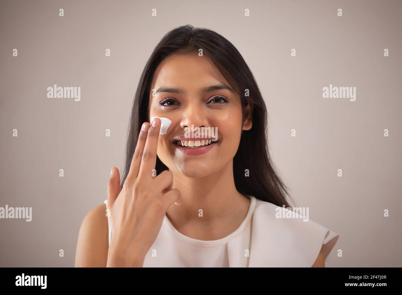 A YOUNG WOMAN HAPPILY PUTTING CREAM ON FACE Stock Photo Alamy