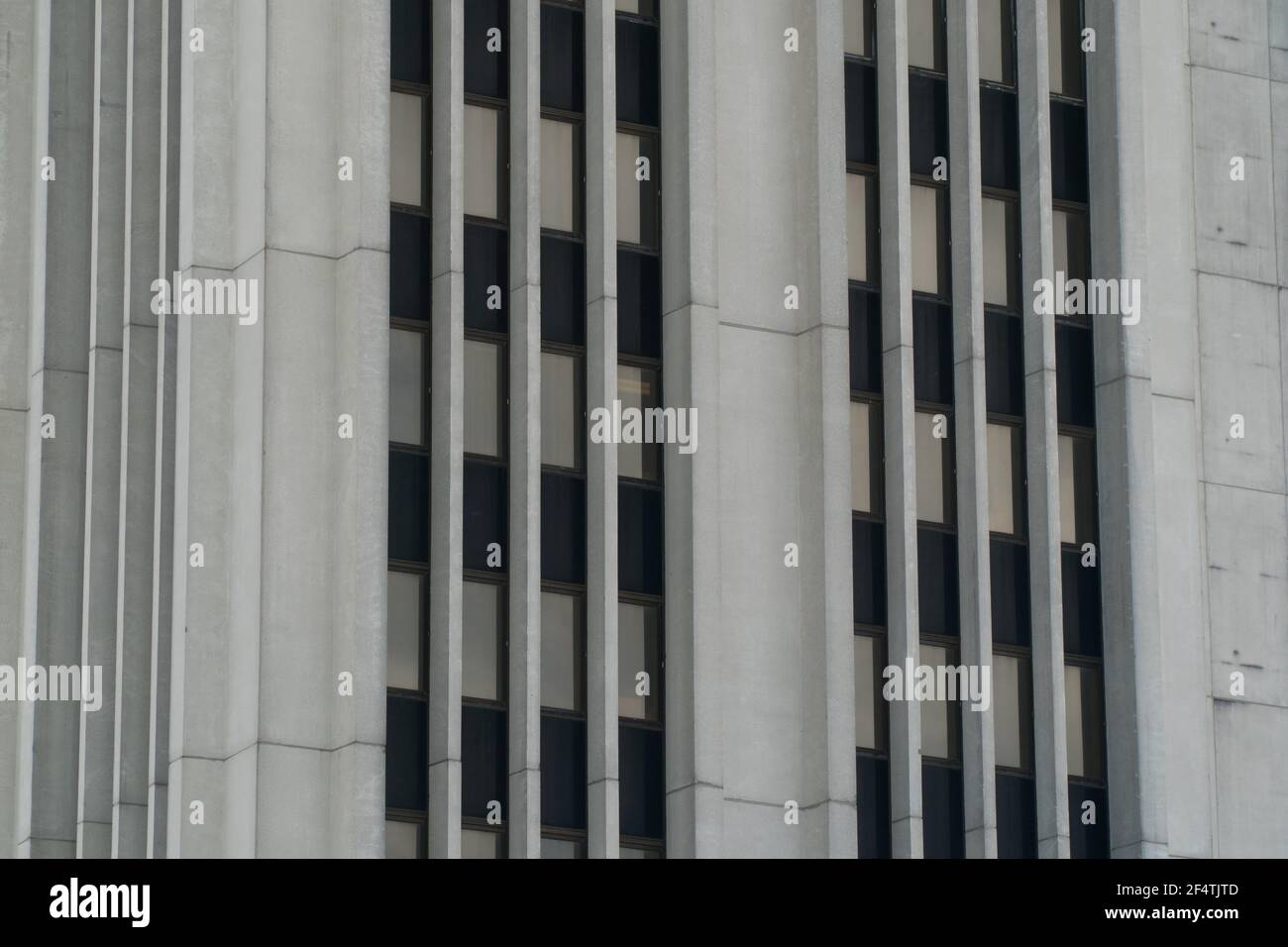 Exterior close up of generic office building skyscraper tower in downtown city area of black windows and concrete construction Stock Photo