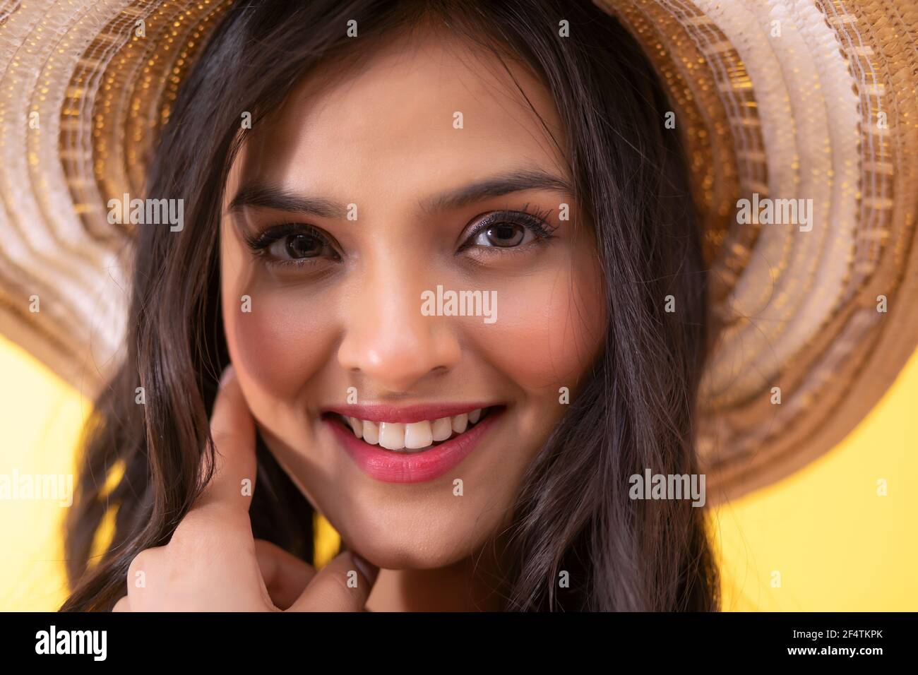 CLOSE SHOT OF A YOUNG WOMAN CHEERFULLY POSING IN FRONT OF CAMERA Stock Photo