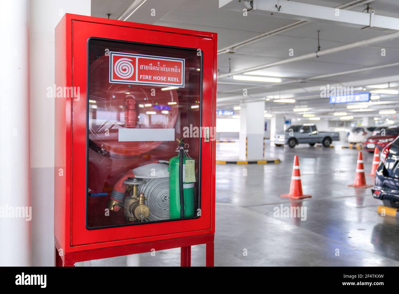 Fire Hose Reel box in the corner of Car Parking., The White Thai Language  letter in the middle of the red box means FIRE HOSE REEL Stock Photo - Alamy