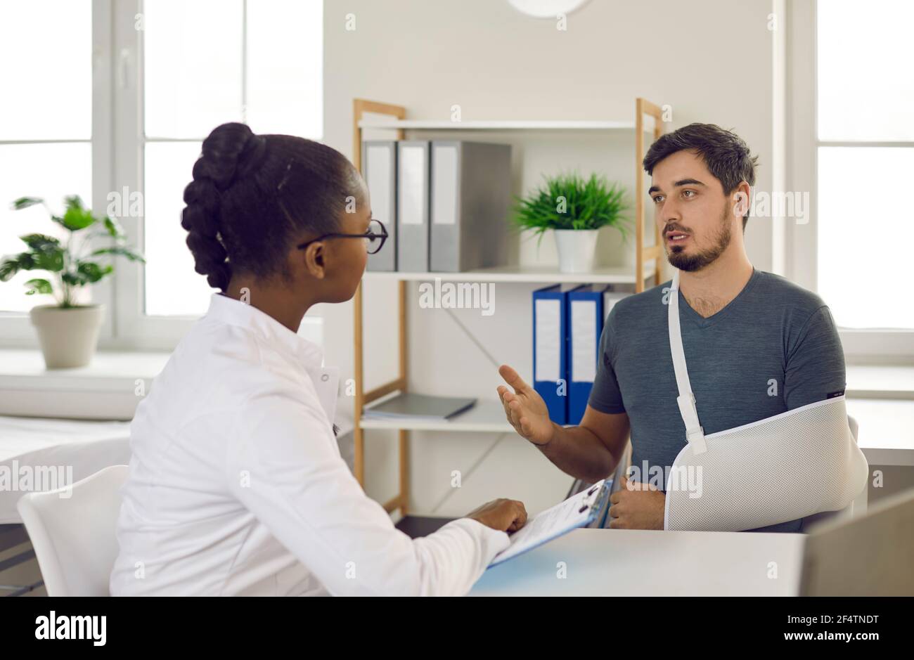 Caucasian man patient and afro american doctor consultation in hospital room Stock Photo