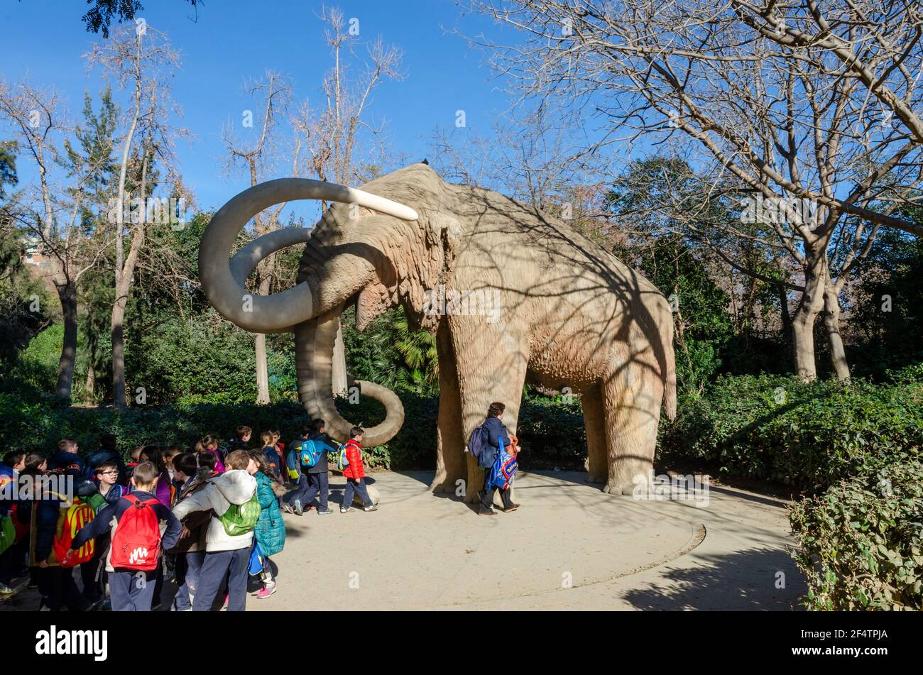 Childre having fun with the Sculpture of a mammoth (Mamut) in Parc de la Ciutadella (Citadel Park). Barcelona, Catalonia, Spain. Stock Photo