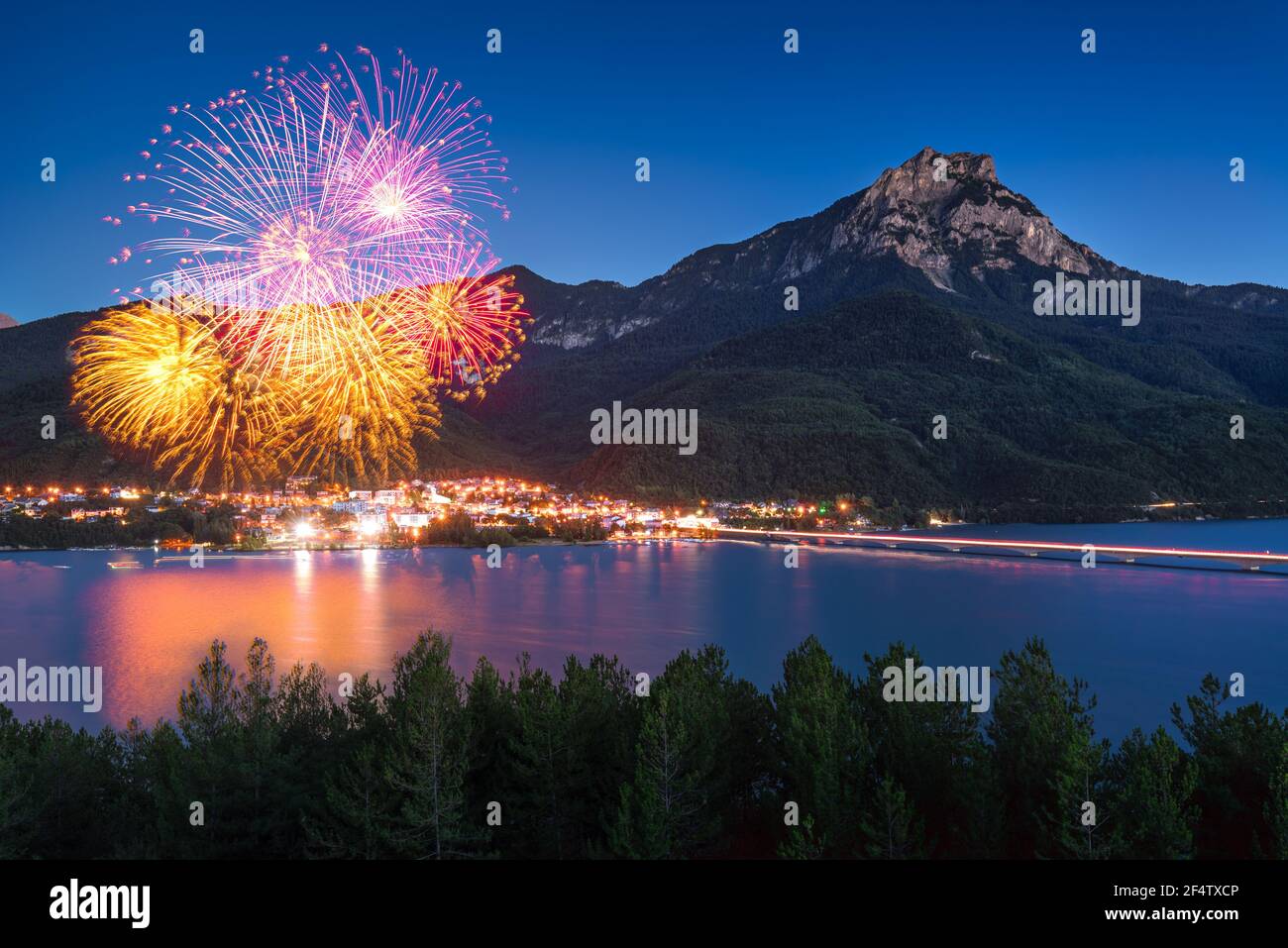 The village of Savines-le-Lac with 14th of July fireworks (Bastille Day). Serre-Poncon Lake in summer with Grand Morgon Peak. Hautes-Alpes, France Stock Photo