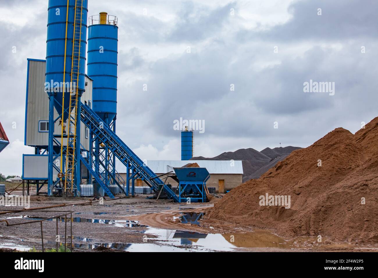 Asphalt mixing plant after the rain on cloudy grey sky background. Stock Photo