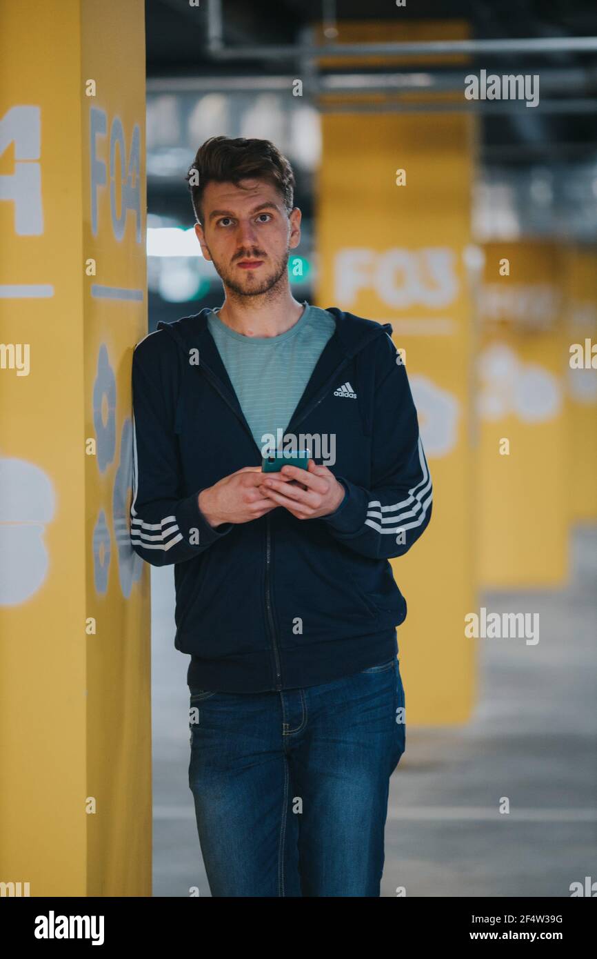BRCKO, BOSNIA AND HERZEGOVINA - Nov 27, 2019: Tall man waerig Adidas in  garage posing for camera Stock Photo - Alamy