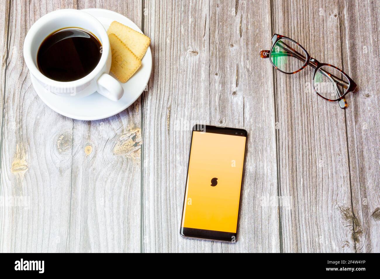 A mobile phone or cell phone laid on a wooden table with the Soundhound ...