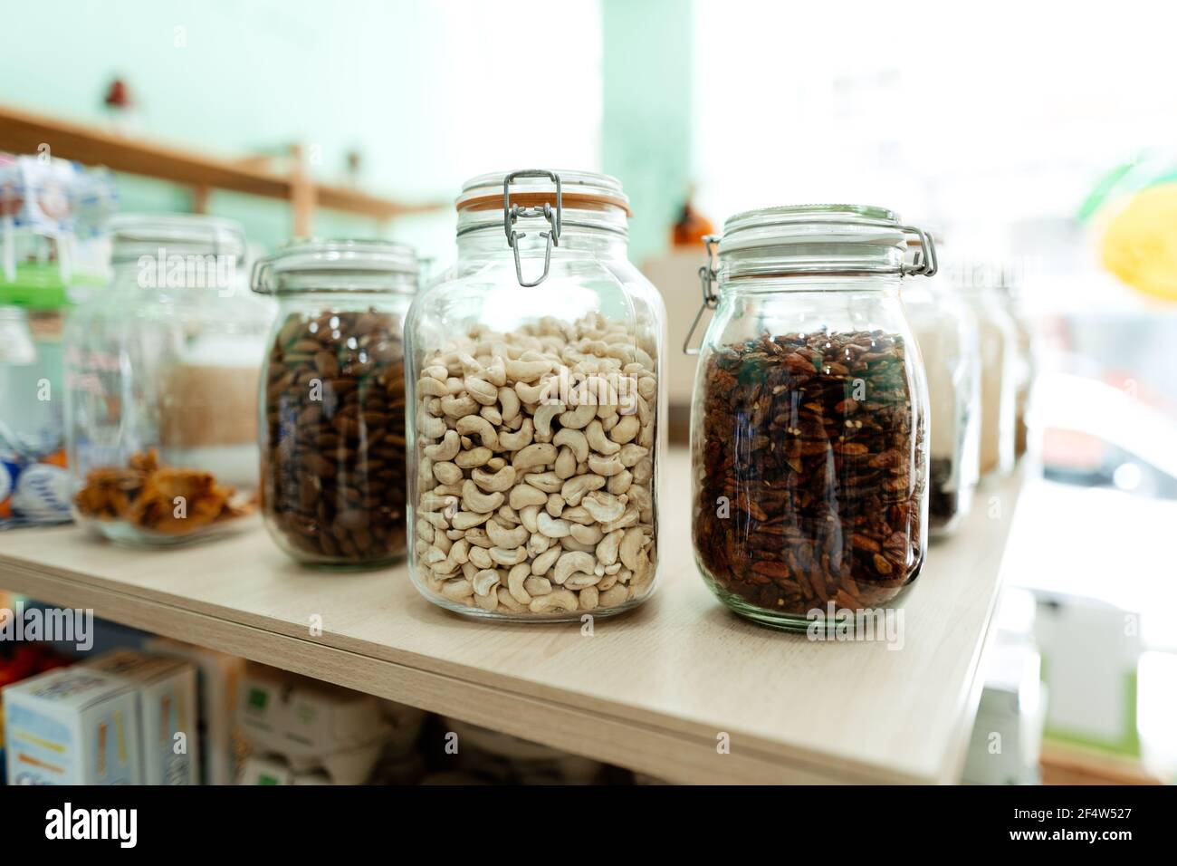 Glass jar with cashew nuts, dry chilli and almonds at a local organic marketplace Stock Photo
