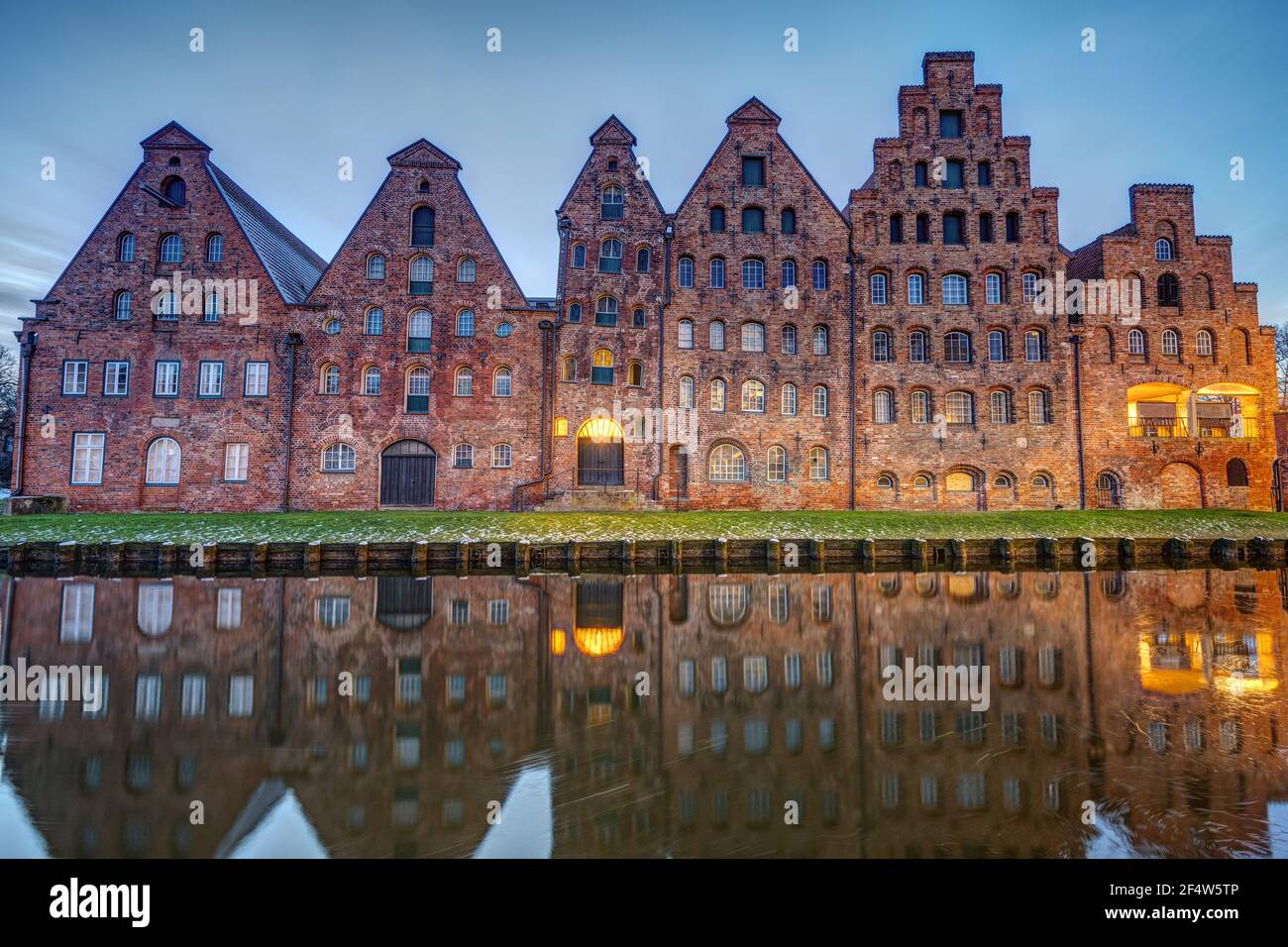 The old Salzspeicher reflecting in the Trave river at dawn, seen in Luebeck, Germany Stock Photo
