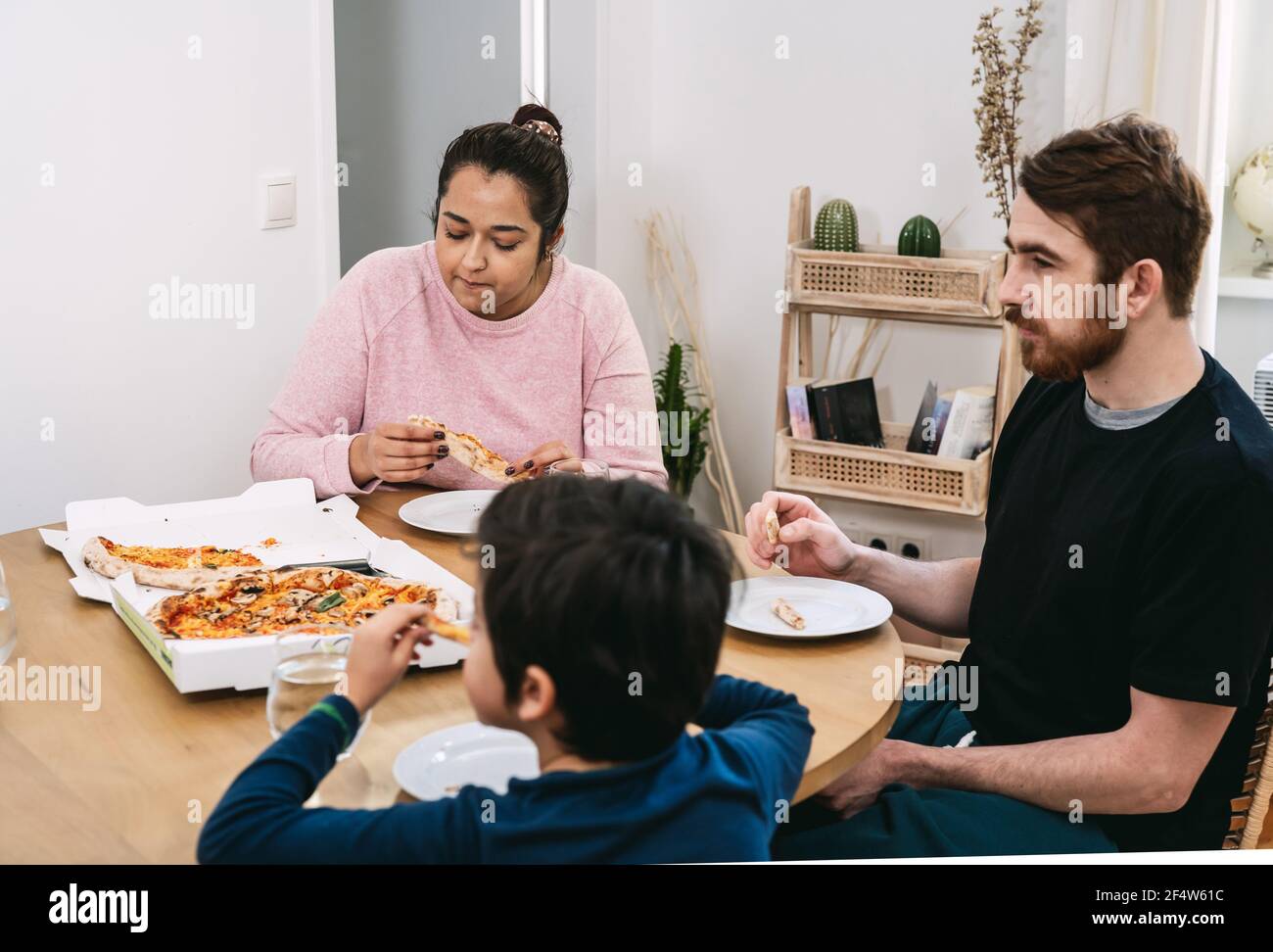 Multinational family eating vegan pizza at home Stock Photo