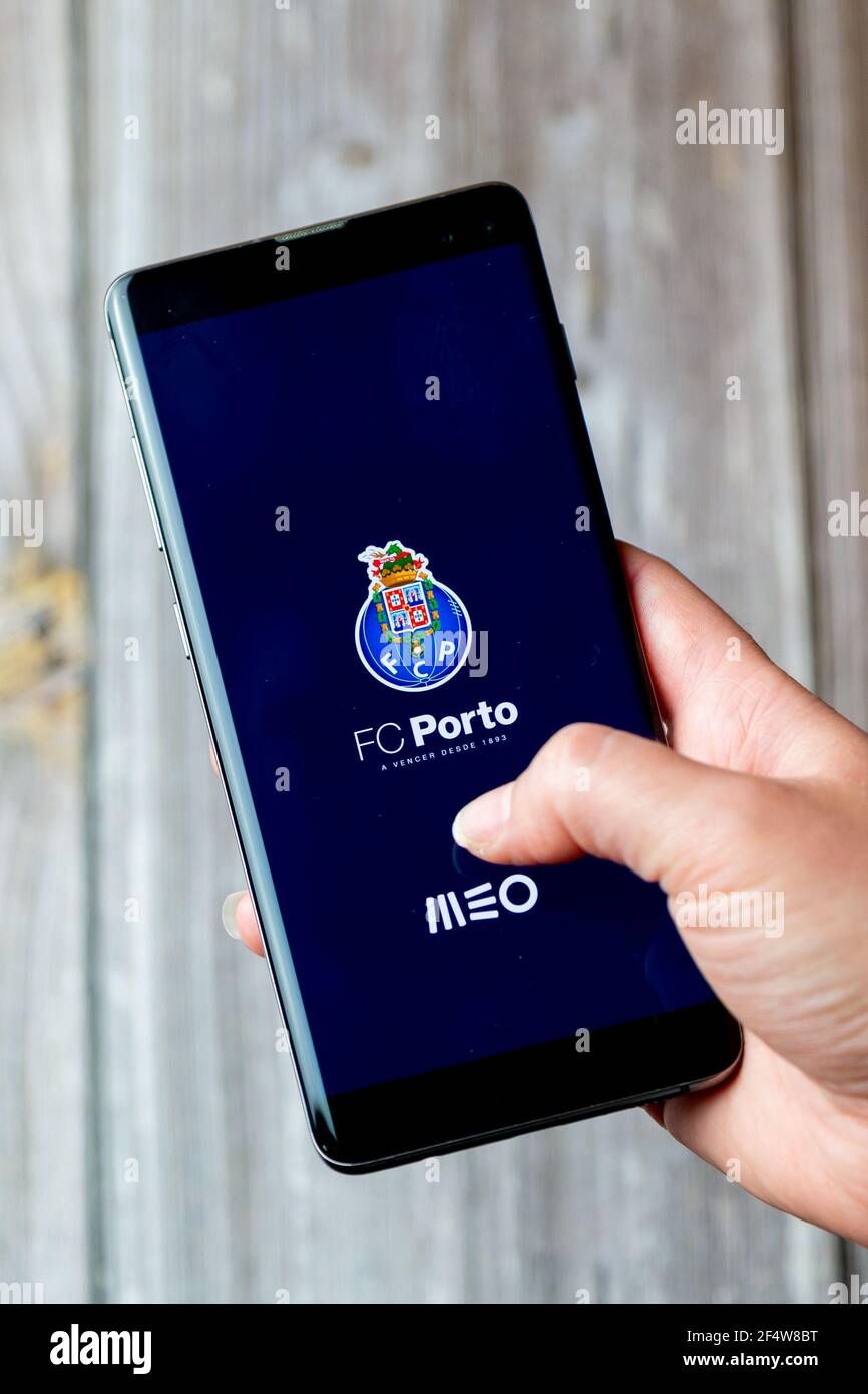 A mobile phone or cell phone being held in a hand with the FC Porto app open on screen Stock Photo