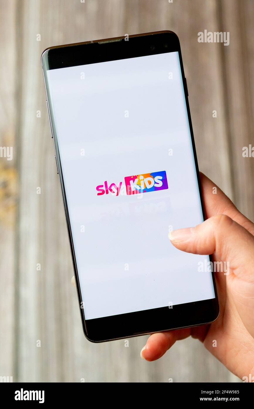 A mobile phone or cell phone being held in a hand with The Sky kids app open on screen Stock Photo