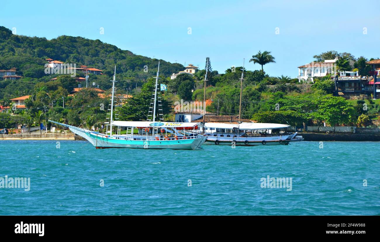 Landscape with view of a traditional sightseeing Schooner on the waters of Armação dos Búzios, the renown resort town of Rio de Janeiro, Brazil. Stock Photo