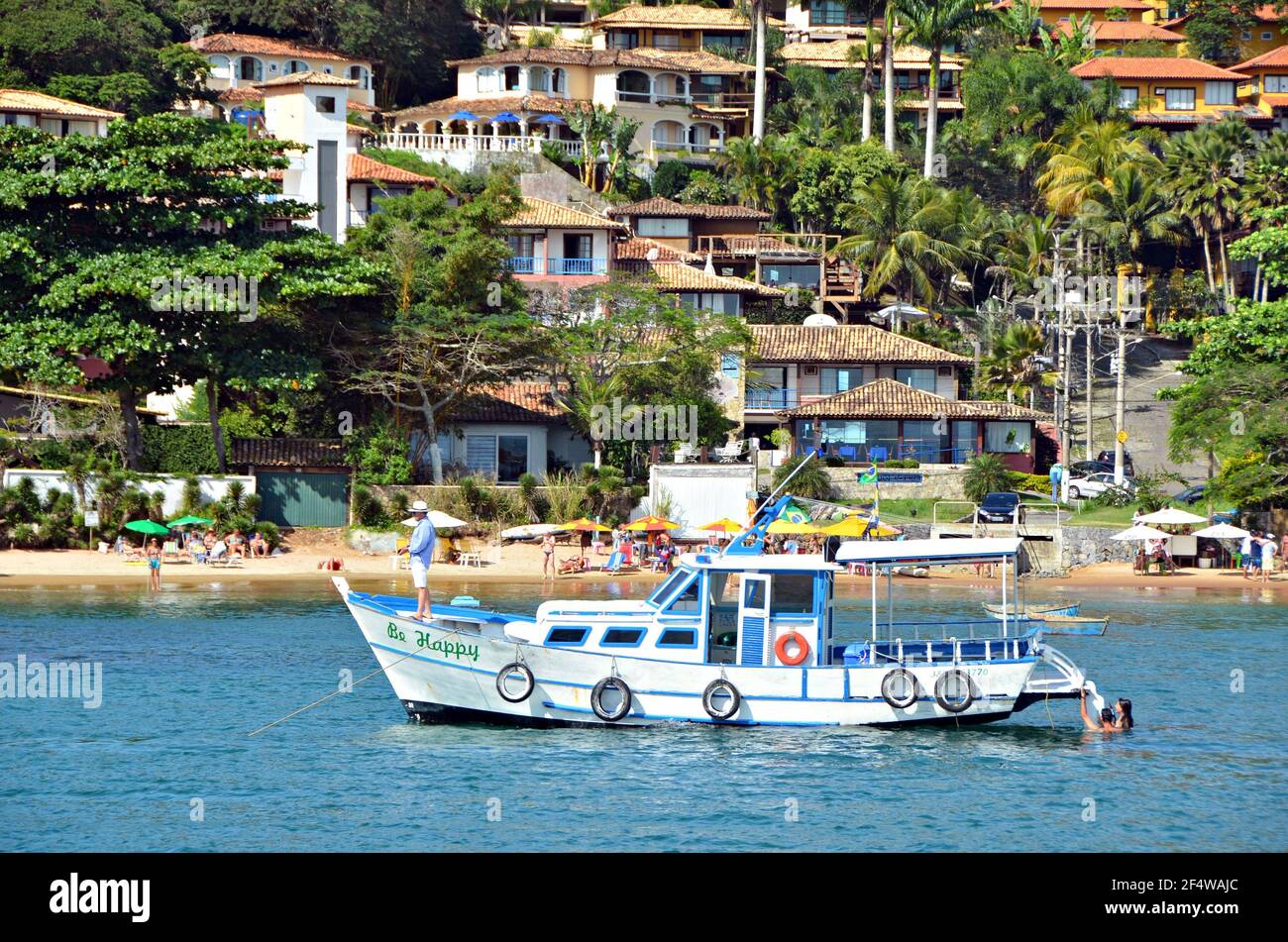 Landscape with view of a traditional sightseeing tour boat on the waters of Armação dos Búzios, the renown resort town of Rio de Janeiro, Brazil. Stock Photo