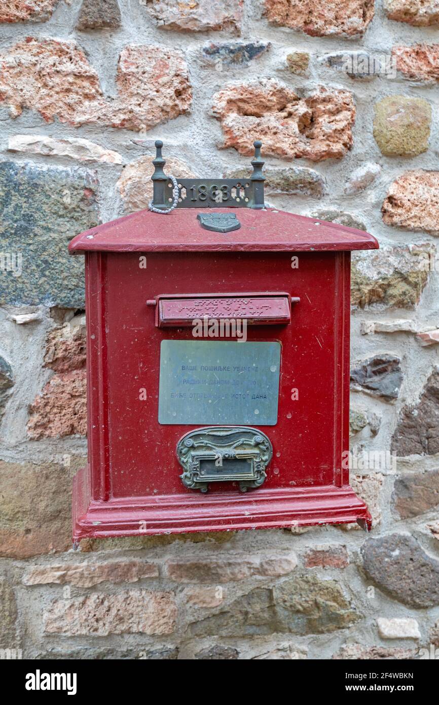 Kraljevo, Serbia - April 16, 2018: Classic Red Mail Box at Old Stone Wall Stock Photo