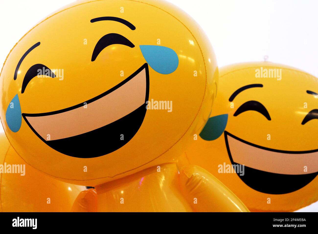 A couple of inflatable yellow laughing emojis. Stock Photo