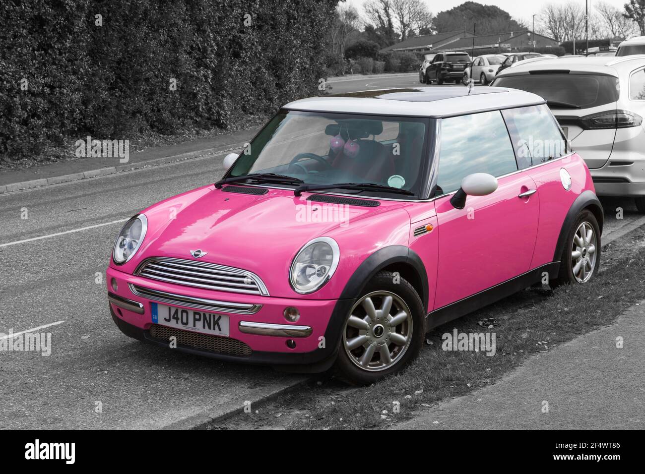 Pink Mini Cooper car with personalised number plate, registration plate, parked in road at Bournemouth, Dorset UK in March Stock Photo