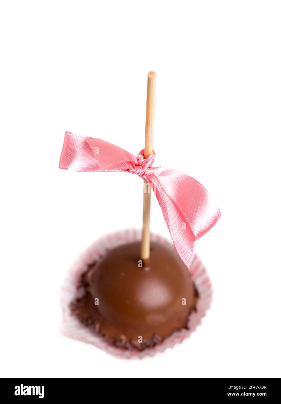 Delicious chocolate glazed candy on stick with pink silk ribbon. Macro